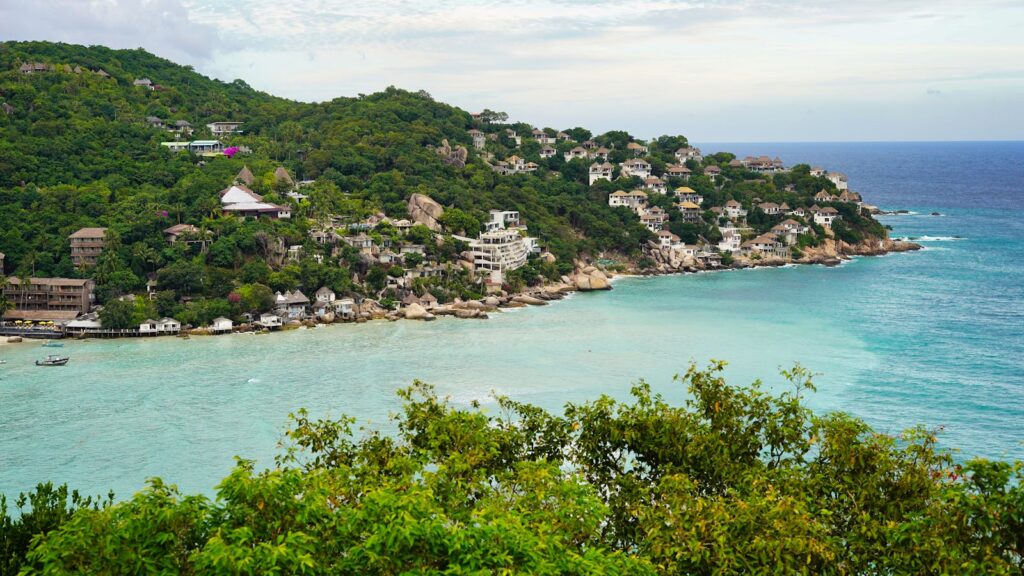 Breathtaking aerial view of Koh Tao's Shark Bay with turquoise waters and lush greenery in Thailand.