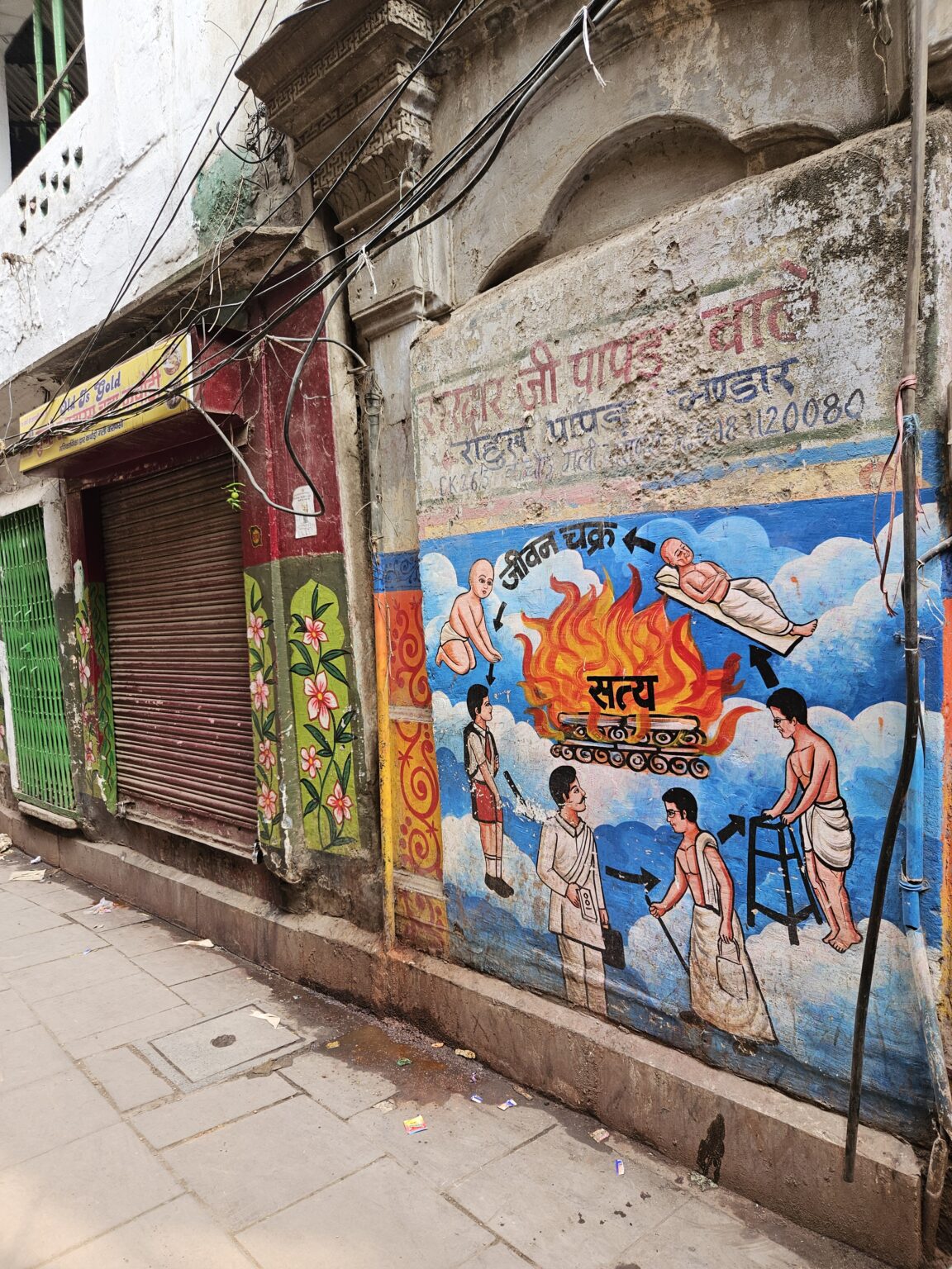 Muurschildering in Varanasi toont de cyclus van leven, dood en crematie in de hindoecultuur.