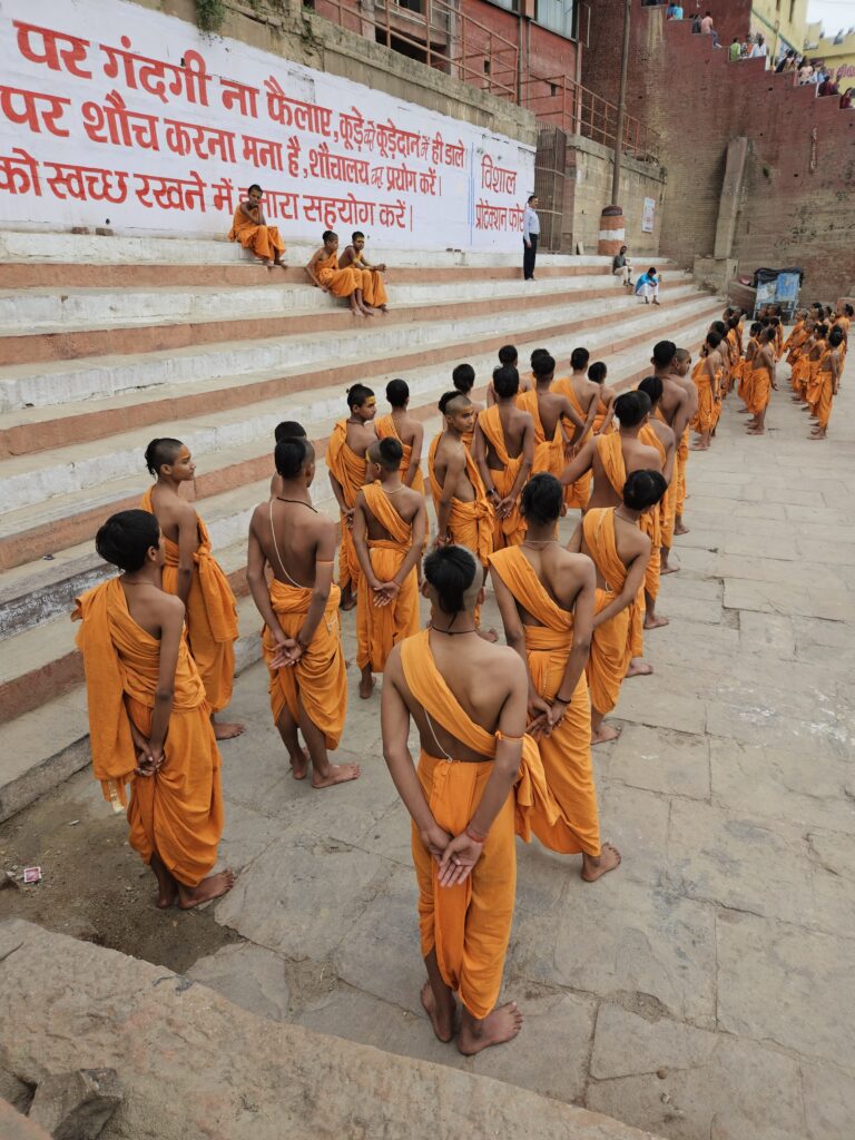 Jonge monniken in oranje gewaden in Varanasi, India, tijdens spirituele training aan de ghats van de Ganges