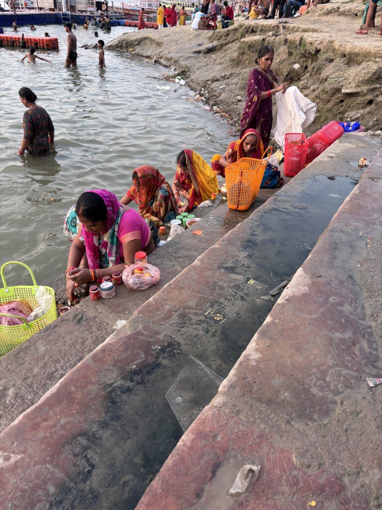 Vrouwen in kleurrijke sari’s bereiden offers langs de trappen van de Ganges in Varanasi, India.